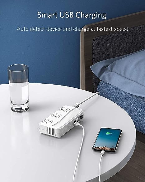 BESTEK 250W travel voltage converter — USB charging a phone beside a bed