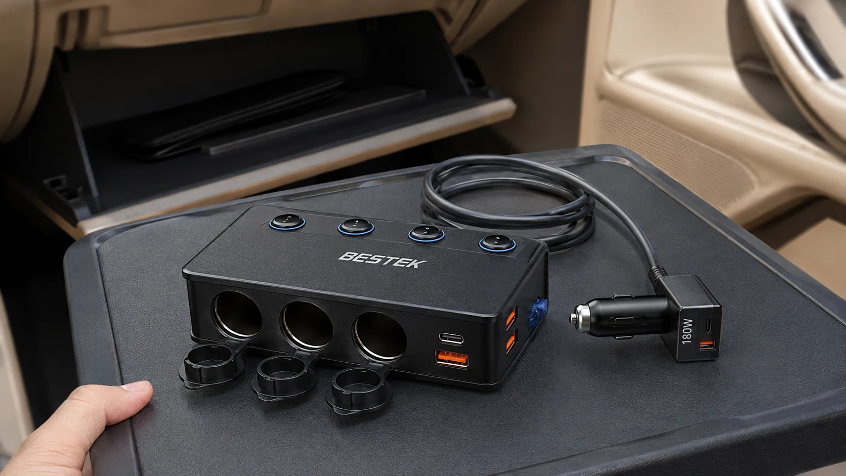 Disconnected car splitter and supply plug on a handheld tray beside an open glove compartment