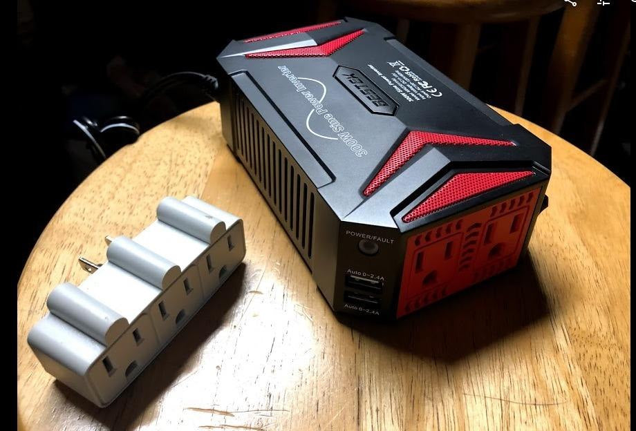 Review photo of a BESTEK 300W pure sine inverter with an outlet adapter.